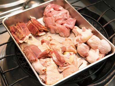 アワビと煮込む材料には、アワビ１に対して、親鶏の肉１、豚モモ肉0.5、金華ハム0.5、鶏の足0.5、ネギとショウガを少々用意する。