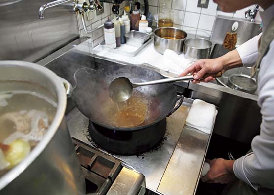 にしぶち飯店 西淵さんが、フカヒレの土鍋煮込みを調理中。オイスターソース、醤油などで上湯の味をフカヒレ用に調える。