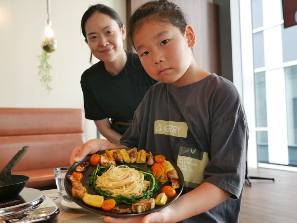 ワークショップで完成した料理を持つ子ども