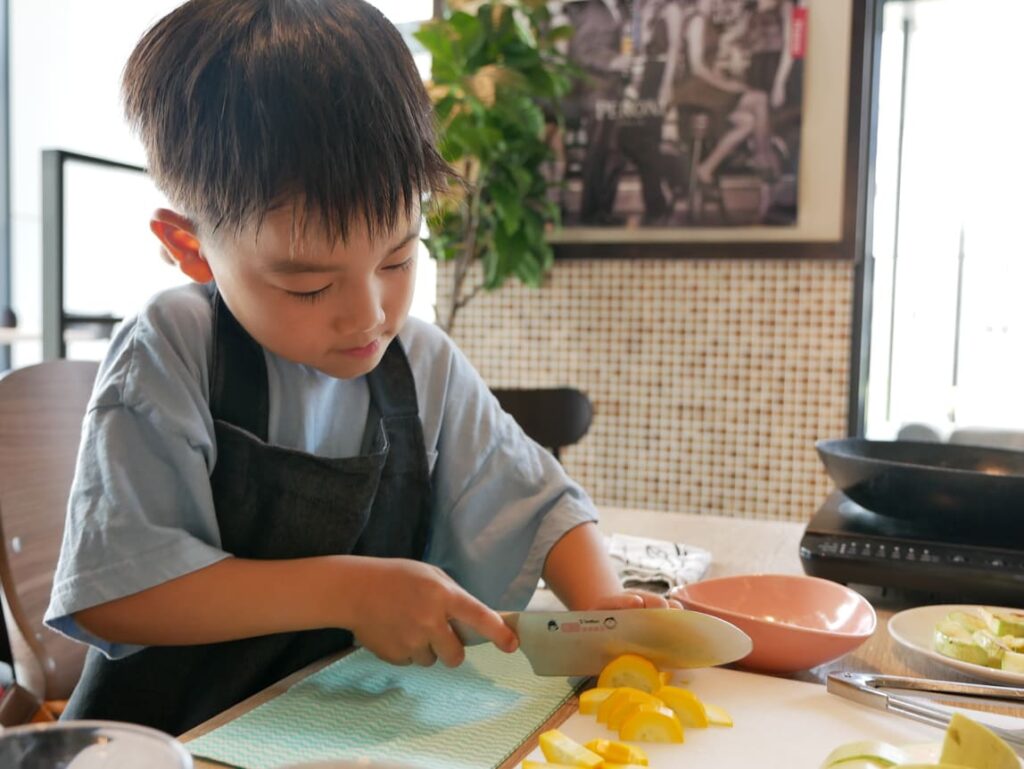 包丁を手に具材を切る男の子
