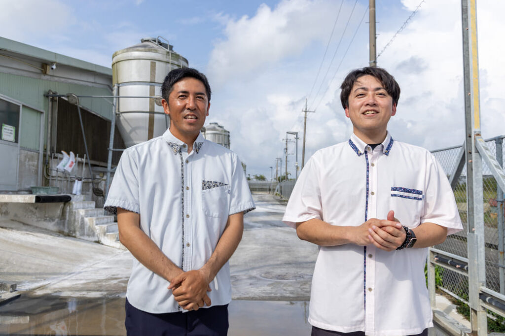 「病気になりにくい豚を目指し研究した自慢のエサがおいしさの秘密」と話す崎原秀俊さんと崎原太位作さん。