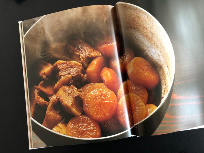 『佐伯義勝料理写真の世界』見開きいっぱいに写し出された「大根と角煮」、鍋からは湯気が上がっている。